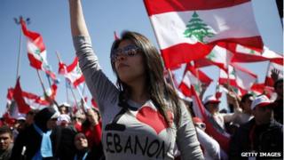 Protesters wave Lebanese flags during a demonstration in Beirut on the anniversary of a popular uprising.