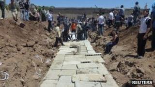 Concrete slabs are seen over a mass burial site for those killed in Friday's attacks in Houla