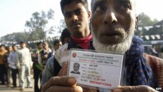 Bangladeshi man holds up a national identity card