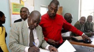Andrew Banda (in the red shirt), eldest son of the former Zambian president Rupiah Banda, being charged in a police station
