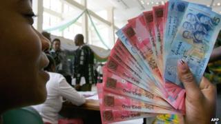 A woman with cedi notes