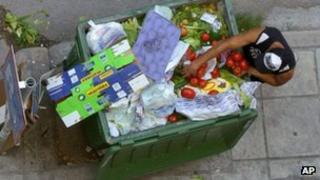 A man searches for food in a bin in Thessaloniki, Greece, 5 June
