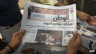 An Egyptian reads a newspaper with front page news about the health of ousted president Hosni Mubarak