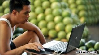 water melon vendor checks his laptop