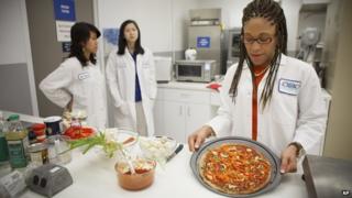 Senior research scientist Maya Cooper shows a vegan pizza developed at NASA's Advanced Food Technology Project.