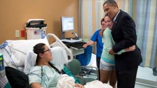 Arlywydd Barack Obama (de) yn cofleidio Stephanie Davies (ail o'r dde ), aachubodd fywyd ei ffrind Allie Young (chwith)