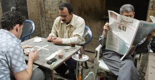 Street cafe with man reading newspaper