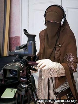 A female camera operator wearing a niqab