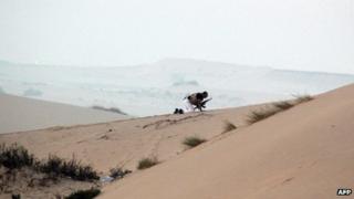 A member of the Egyptian security forces takes position on a sand dune during an operation in the northern Sinai peninsula on August 08, 2012