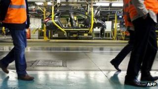 Visitors pass Peugeot production line