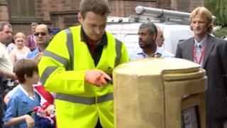 Royal Mail worker painting postbox