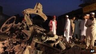 Pakistani rescue workers and investigators look at a vehicle in which a bomb was planted at Mattani, outside Peshawar.