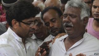 Relatives mourn the death of loved ones during a funeral for garment factory victims in Karachi on 13 September 2012.