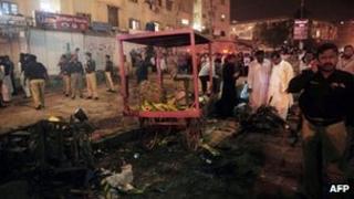 Pakistani security officials scan the site of a bomb explosion in Karachi