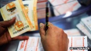 A woman fills out a Mega Millions lottery ticket form at Liquorland on March 30, 2012 in Covina, California