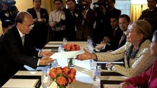 Burma's President Thein Sein hands US Secretary of State Hillary Clinton an envelope as they meet in New York on 26 September 2012