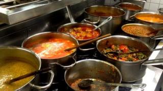 Curries being cooked on large stove