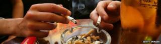 People smoking and having an alcoholic drink