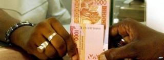 A bank teller gives a customer money in Senegal (Archive 2004)