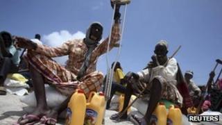 Internally displaced people wait for food aid