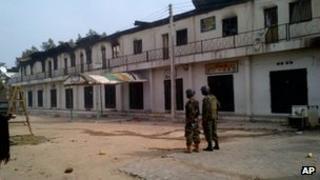Soldiers stand near burnt shops in Maiduguri - 8 October