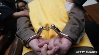 File photo: A crime suspect being handcuffed in China