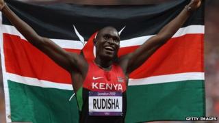 David Lekuta Rudisha of Kenya celebrates with his country's national flag after winning gold and setting a new world record of 1.40.91 in the Men's 800m Final on Day 13 of the London 2012 Olympic Games at Olympic Stadium on August 9, 2012 in London, England.