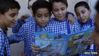 Children read an edition of Qaws Quzah (Rainbow) magazine in Tunis
