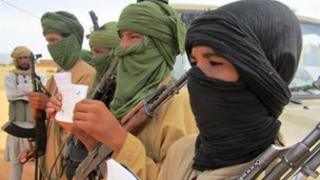 Young fighters, including 13-year-old Abdullahi, right, and 14-year-old Hamadi, second right, display their Quranic studies notes as their Islamist commanders look on, in Douentza, Mali, 27 September 2012
