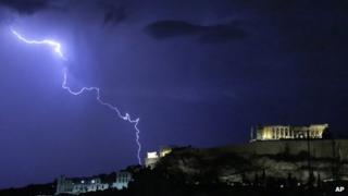 Lightning illuminates the ancient Parthenon temple on top of the Acropolis hill in Athens on 14 October 2012