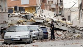 Police officer inspects earthquake damage