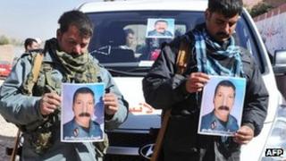 Afghan police officers hold a picture of their commander, killed during combat with Taliban forces in Herat's Obe district.