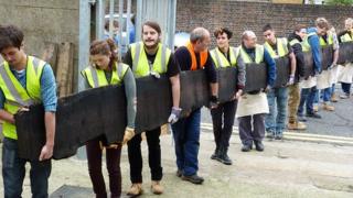 Project team carry the bog oak to the kiln