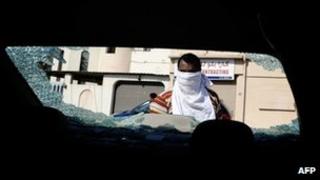 man inspects damage to car in Bahrain (9 November, 2012)