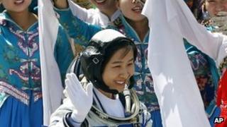 China's first female astronaut Liu Yang waves during a sending-off ceremony as she departs for the Shenzhou 9 spacecraft rocket launch pad (16 June 2012)