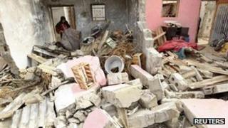 A Palestinian woman surveys damage from an Israeli air strike in Rafah, 11 Nov