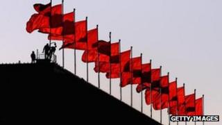 Workers check the security camera under a line of red flags on the top of Great Hall of the People, 13 Nov 2012
