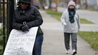 Woman holding 'idiot' sign