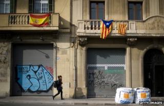 A Spanish flag (left) hangs beside Catalan flags on a Barcelona street, 22 November