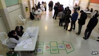 People queue to cast their ballots at a polling station in Barcelona.
