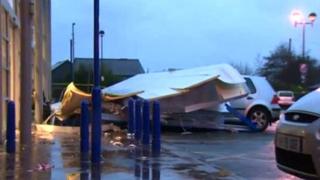 The sign was blown on top of a line of parked cars outside the Bangor store