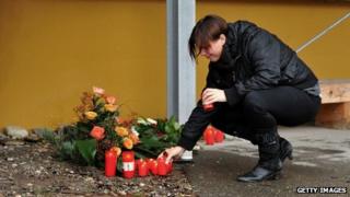 A women lights a candle at a Caritas employment facility for the handicapped where a fire killed 14 people on November 27