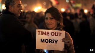 A protester holds a placard against the Egyptian president at an opposition rally in Tahrir Square in Cairo, Egypt, Tuesday, Nov. 27,