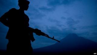 A militia soldier in eastern DR Congo on guard with a volcano in the background (Archive shot February 2008)