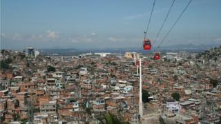 Cable cars travel above the Complexo do Alemao shanty town in Rio de Janeiro
