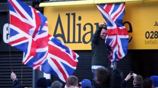 Loyalists erect flags on Alliance Party offices