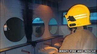 Jersey firefighter inspects damage caused by fire in toilets at Grainville School