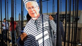 Image of convicted politician Jose Dirceu wearing prison clothes is held by a protester outside the Supreme Court headquarters in Brasilia, Brazil, on 3/8/12
