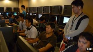 Customers sit at computer terminals in a Philippines internet cafe.