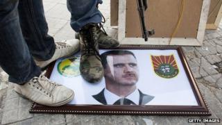 Syrian rebels stand on a picture of President Bashar al-Assad (20 August 2012)